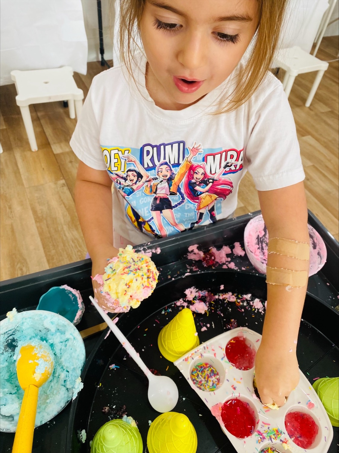 Child mixing colourful dough at a B.Curious creative play session