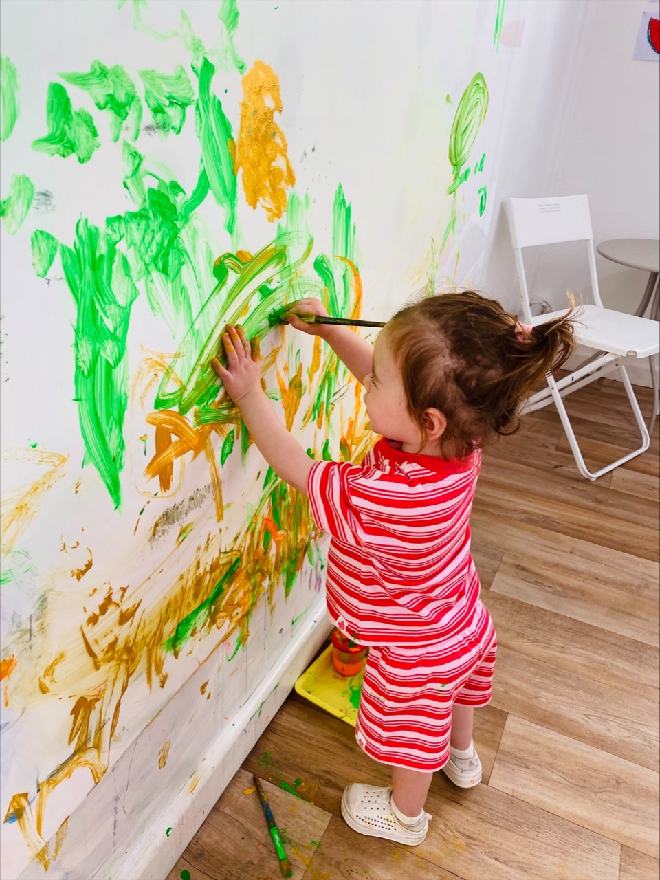 Toddler painting at a B.Curious creative play session